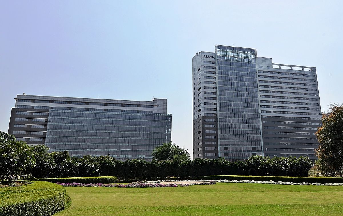 Emaar Digital Greens towers viewed from the landscaped lawn, with EMAAR signage on the facade