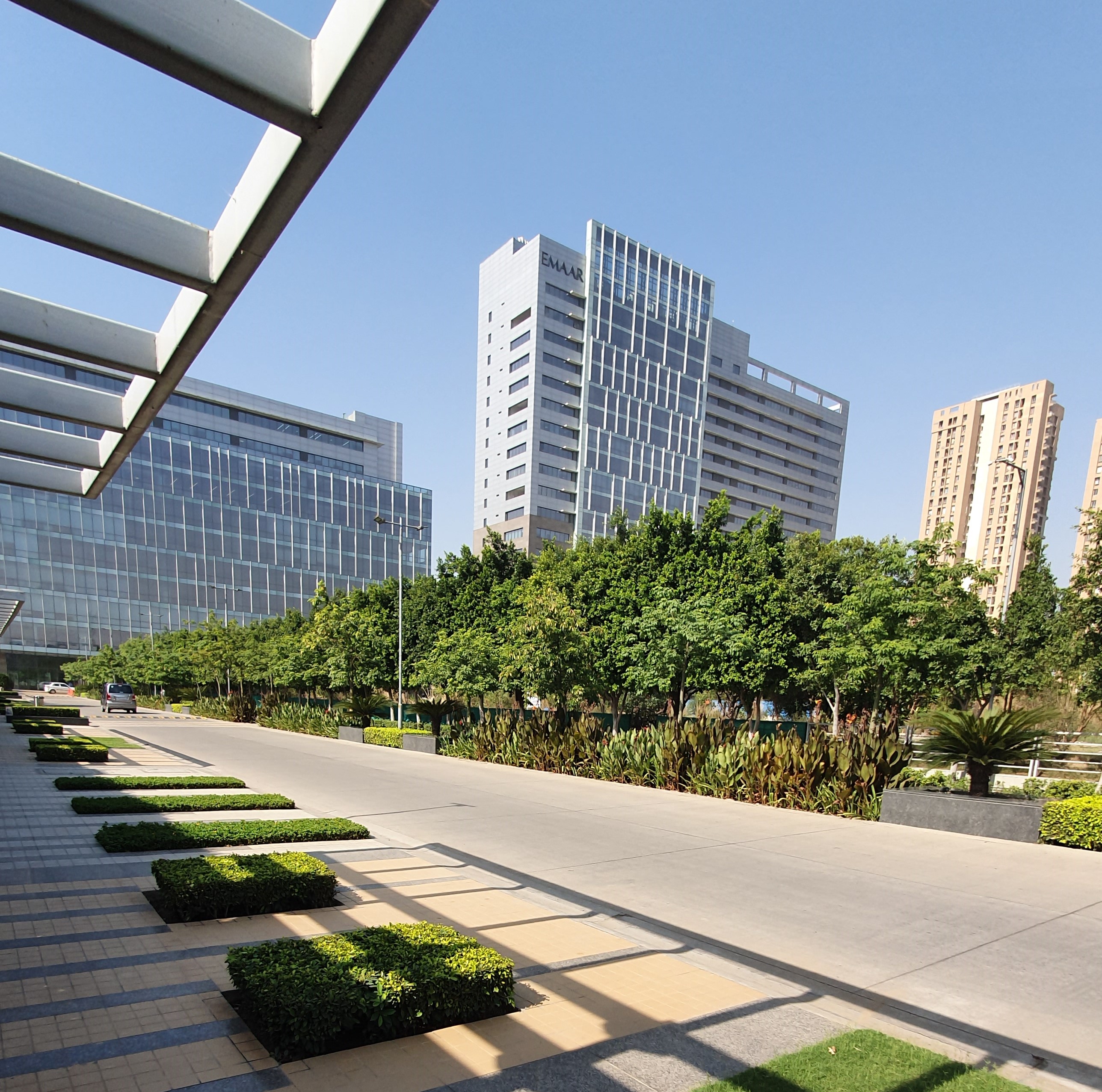 Street-level view of the Digital Greens campus with EMAAR branding visible on the tower