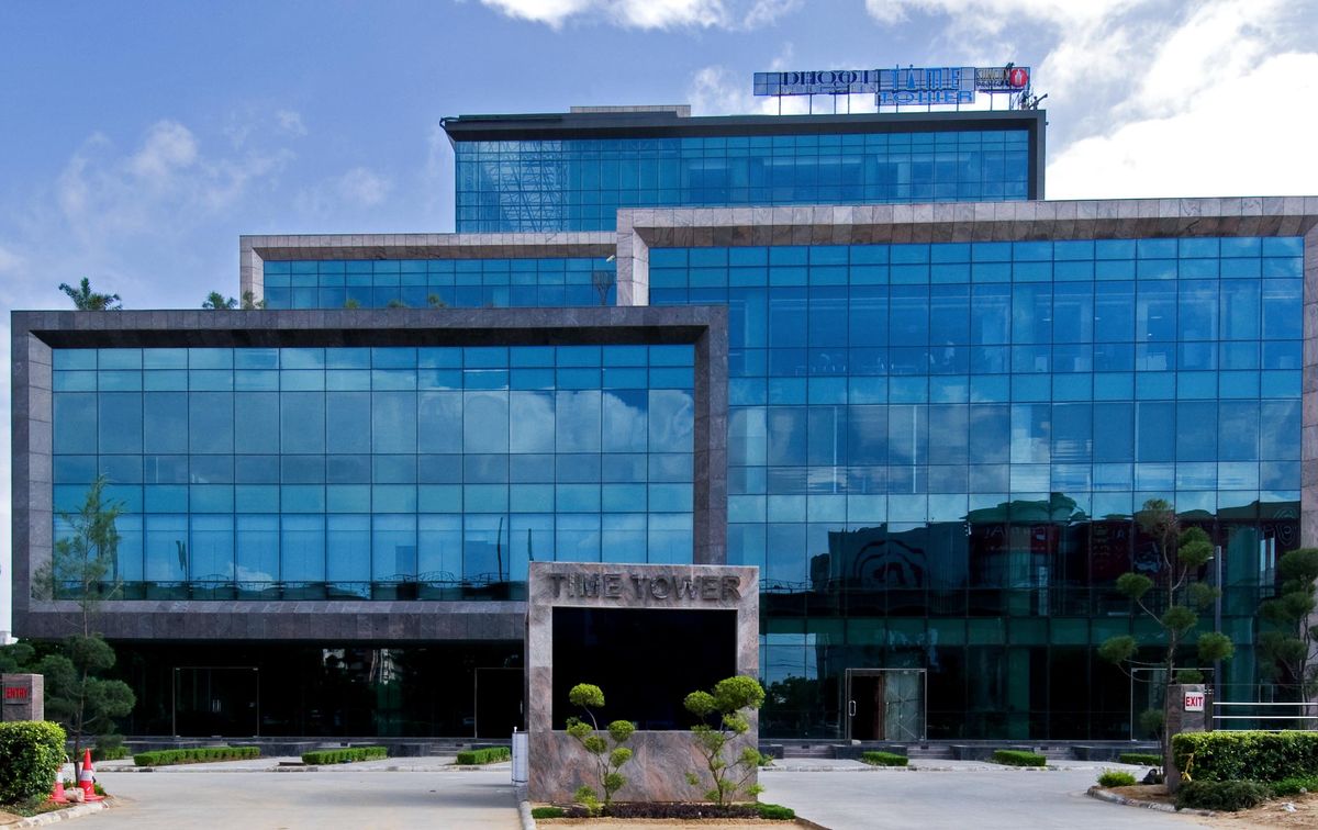 Close exterior view showing the glass facade and building name signage